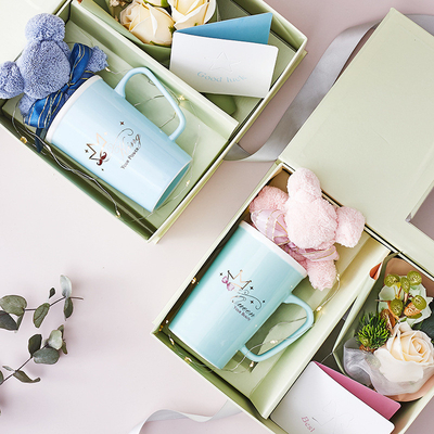 Une tasse en céramique créative, une serviette, un savon, un bouquet de cartes de vœux, des souvenirs.