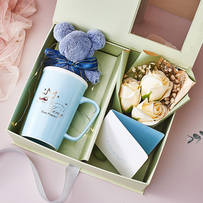 Une tasse en céramique créative, une serviette, un savon, un bouquet de cartes de vœux, des souvenirs.